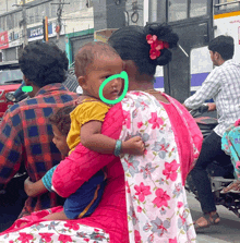 a woman is holding a baby in her arms with a green circle around her face