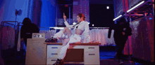 a woman is sitting on a desk with her leg up and giving the middle finger