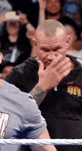 a man is covering his face with his hand while standing in a ring .