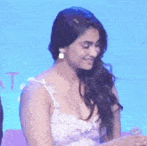 a woman in a white dress with a plunging neckline is smiling .