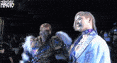 two women are standing next to each other in front of a crowd with monday magic written on the bottom of the screen .
