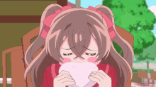 a girl with pigtails is holding a heart shaped object in her hands
