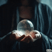 a woman is holding a crystal ball in her hands with pixiz written on the bottom right
