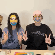 a woman wearing a nashville sweatshirt is sitting at a table with other people