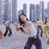 a girl in purple pants and a white tank top with the number 3 on her chest