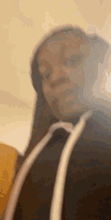 a blurry picture of a woman taking a selfie with a cell phone .