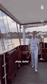 a woman in a white uniform is walking on a boat and says " hola sofia "