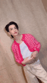 a man wearing a pink cardigan and a white shirt