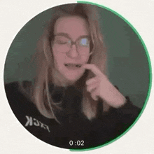 a woman wearing glasses and headphones is making a funny face in a circle .