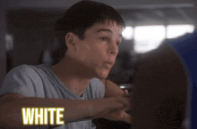 a boy in a white shirt has the word white on his chest