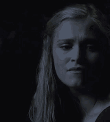 a close up of a woman 's face in the dark with a tear coming out of her eye .