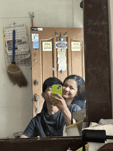 a man and woman are taking a selfie in front of a door that has a sticker on it that says nescafe