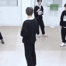 a group of young men are standing in a room with a sign that says rap & dance