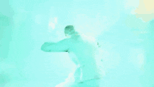 a man in a leather vest is jumping in the air in a blue room .