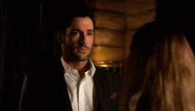 a man in a suit and a woman in a white shirt are looking at each other .