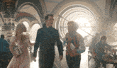 a woman in a pink dress talks to two men