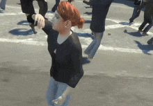 a woman with red hair is standing in a crowd