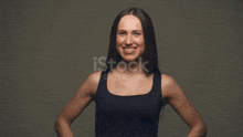 a woman is flexing her muscles in front of a grey background