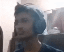 a man wearing headphones is talking on a cell phone in a dark room .