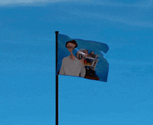 a blue flag with a picture of a man with glasses