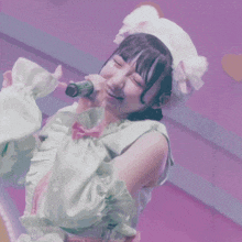 a girl singing into a green microphone wearing a white hat