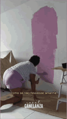 a woman is painting a wall with the words canelanza written on the bottom