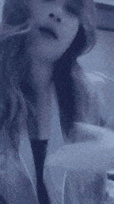 a woman is wearing a purple shirt and taking off her shirt .