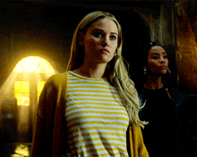 a woman wearing a striped shirt and a yellow cardigan