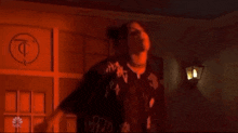 a man is standing in front of a door in a dark room with red lights .