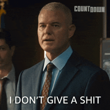 a man in a suit and tie says i don t give a shit