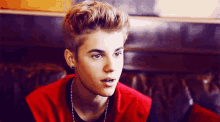 justin bieber is wearing a red jacket and a black shirt