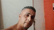 a man without a shirt is looking at the camera with a cigarette in his mouth