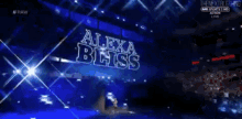 a man is walking on a stage with the name alex black on it
