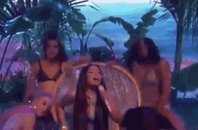 a group of women in bikinis are dancing in a pool with a man .
