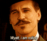 a man with a hat and a mustache says " wyatt i am rolling "