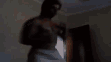 a shirtless man is standing in front of a door in a room .
