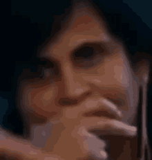 a close up of a woman covering her mouth with her hands .