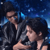 two men are standing next to each other on a stage .