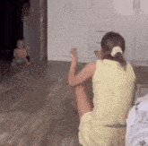 a girl in a yellow dress is sitting on the floor in a living room .