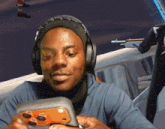 a man wearing headphones holds a game controller