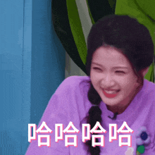 a woman in a purple shirt is smiling with chinese characters behind her