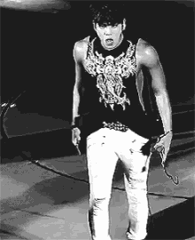 a black and white photo of a man wearing a tank top