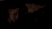 a man and a woman are looking into each other 's eyes in a dark room .