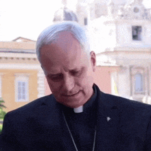 a man in a black suit has a badge on his lapel that says ' cardinal ' on it