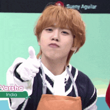 a young man wearing an apron giving a thumbs up in front of a sign that says sueny aguilar