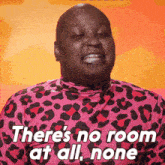 a man in a pink leopard print shirt is saying there 's no room at all none