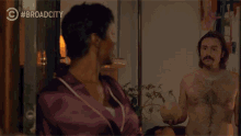 a naked man holding a cantaloupe next to a woman with broad city written in the corner