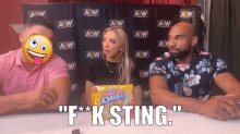 three people sitting in front of a wall that says aew on it