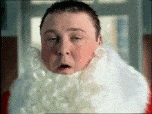 a man with a white beard is making a funny face with his eyes closed
