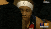 a woman wearing a headband with a basketball player on it looks down
